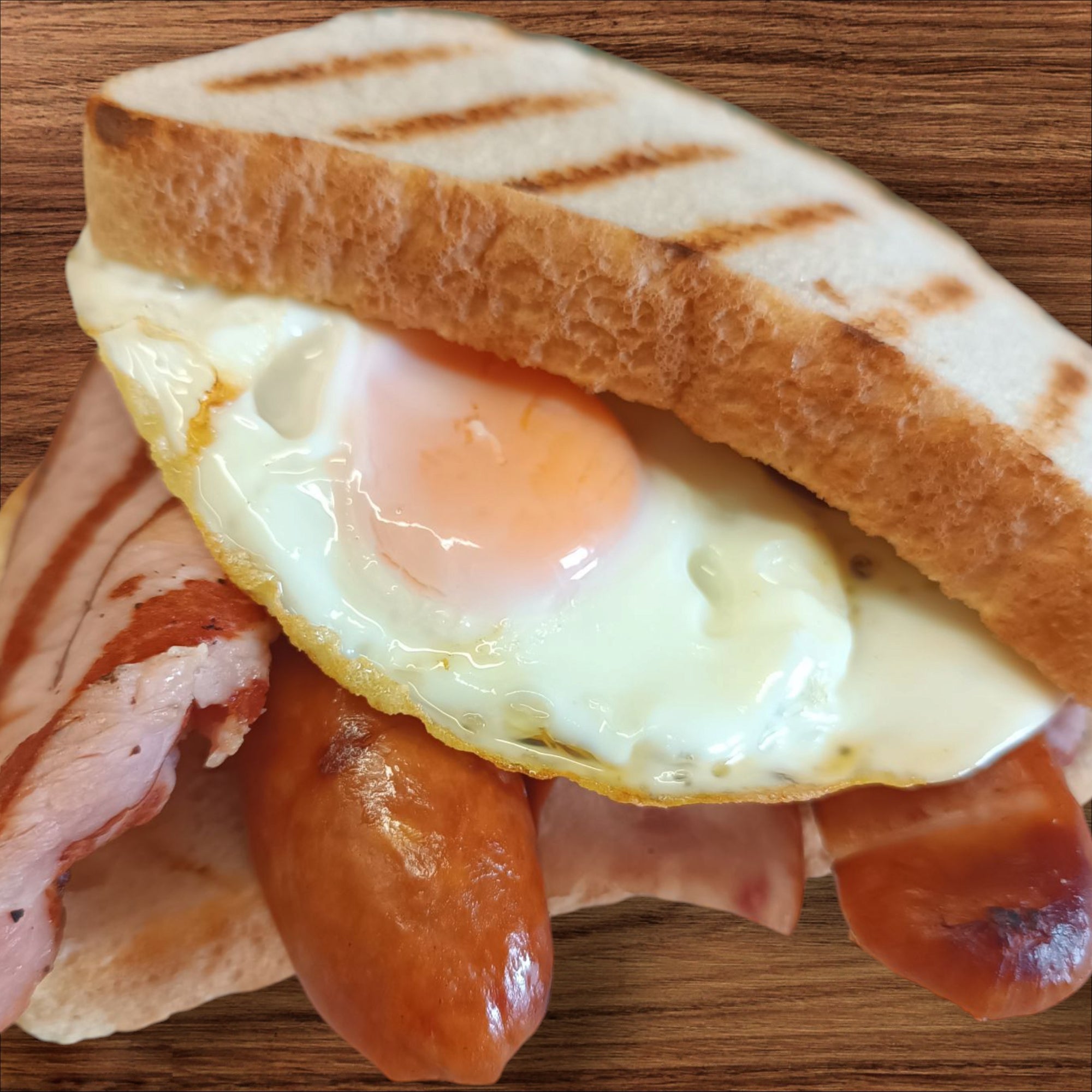Bacon, sausage and eggs sandwich