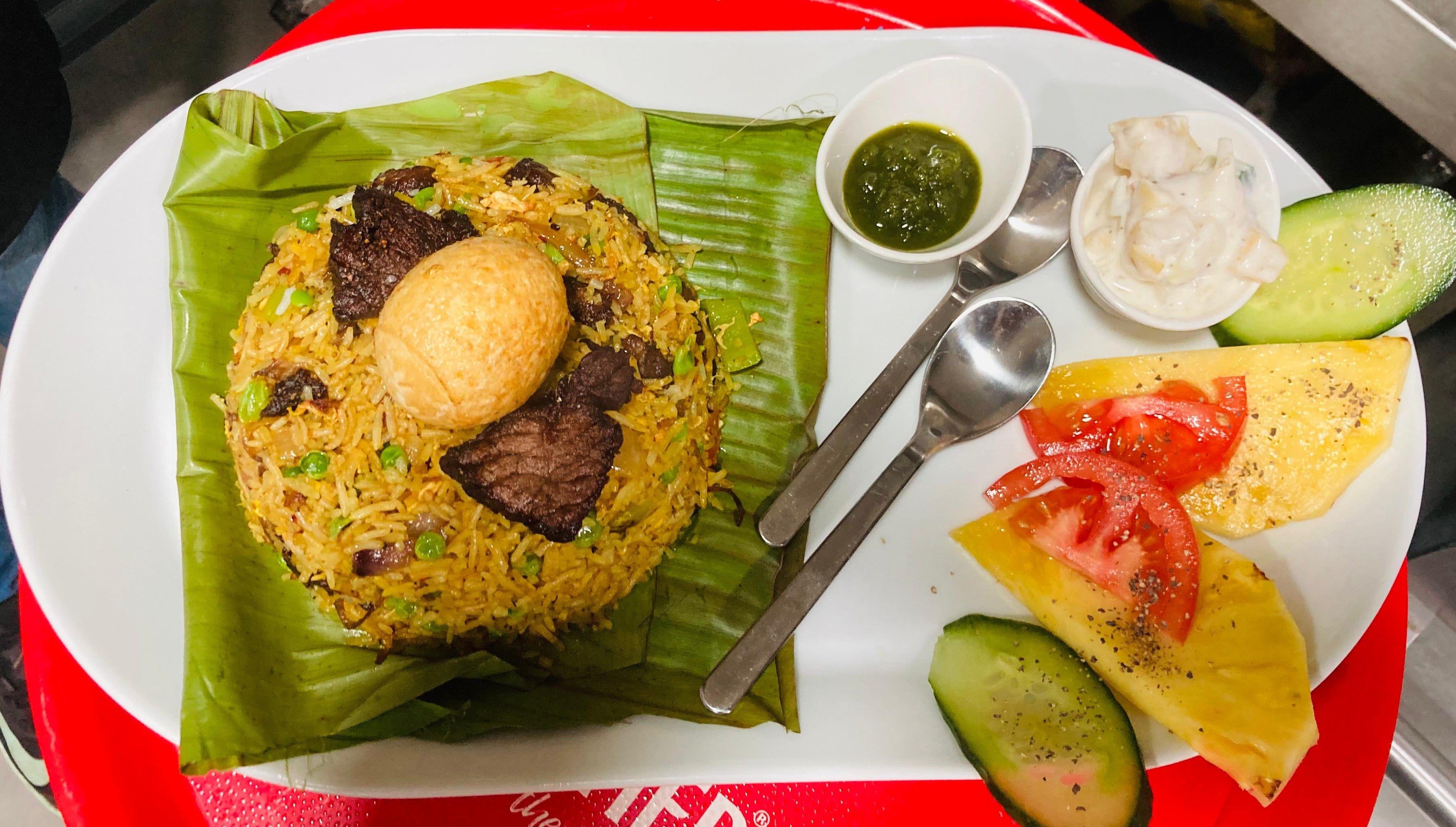Mutton Biryani with mint chutney, raita and a deep-fried hard-boiled egg,