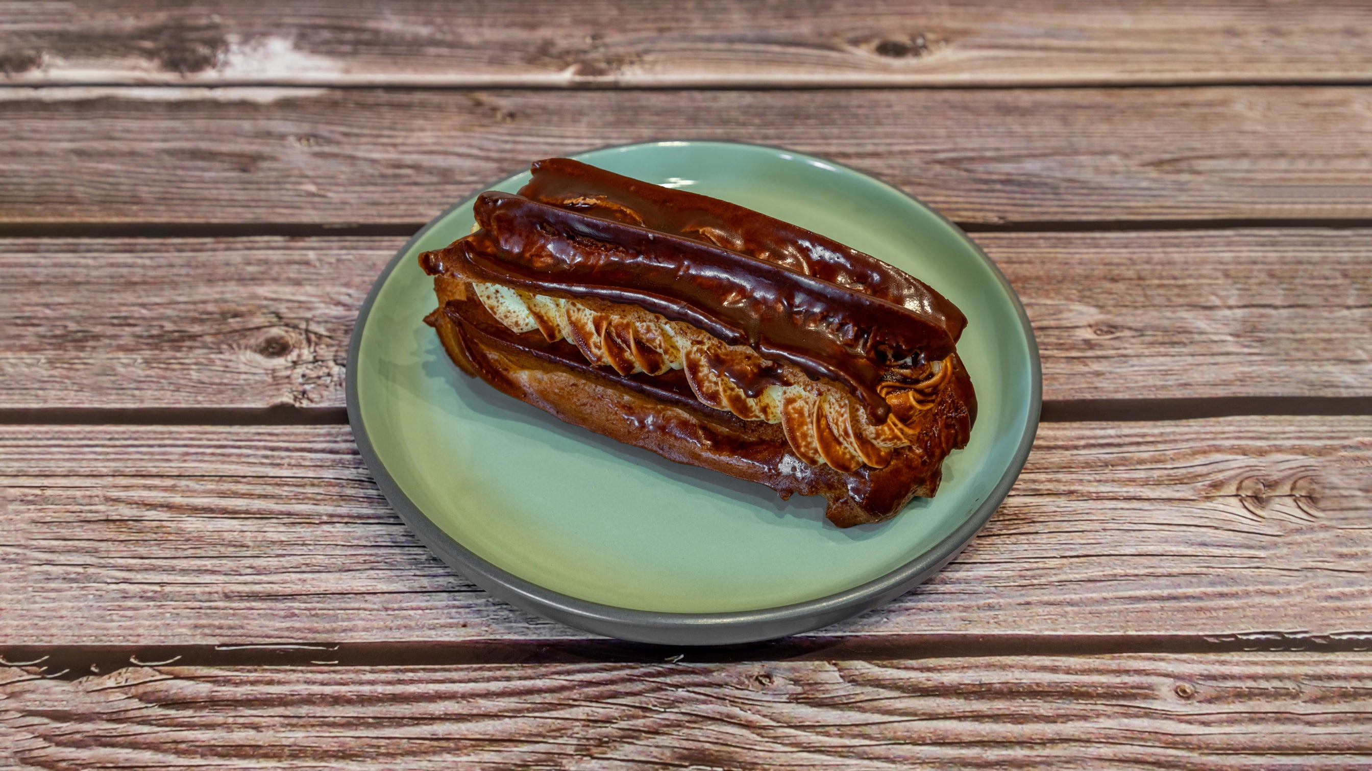 Eclair with custard cream and chocolate. (Eklerka)