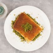A plate of rough Arabic kunafa with animal ghee, cheese and nuts