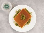 A plate of soft Arabic kunafa with animal ghee, cheese and nuts