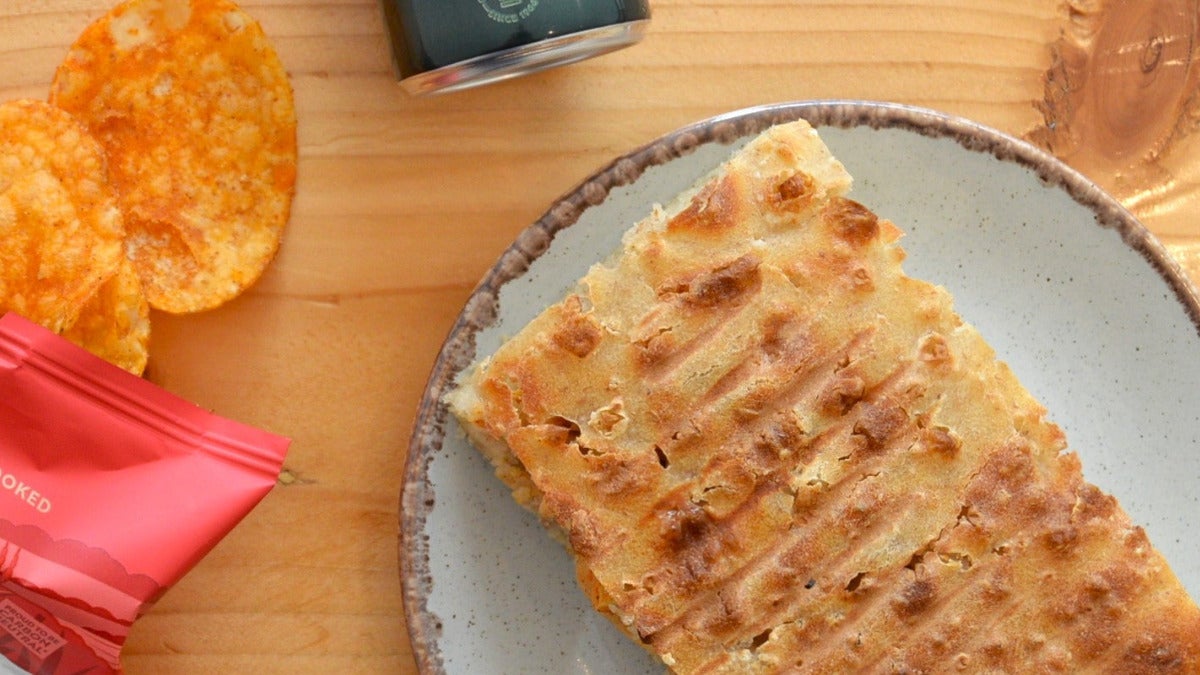 A focaccia sandwich, snack and a drink